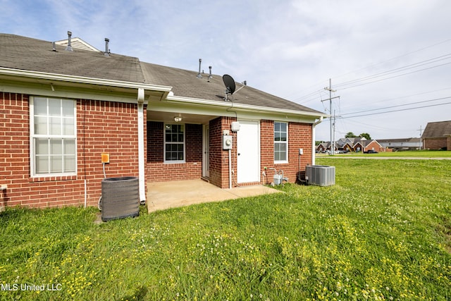7241 Illinois Central Ave, Horn Lake, MS 38637 - rear view of house featuring brick siding, a patio area, a lawn, central air condition unit, and a shingled roof