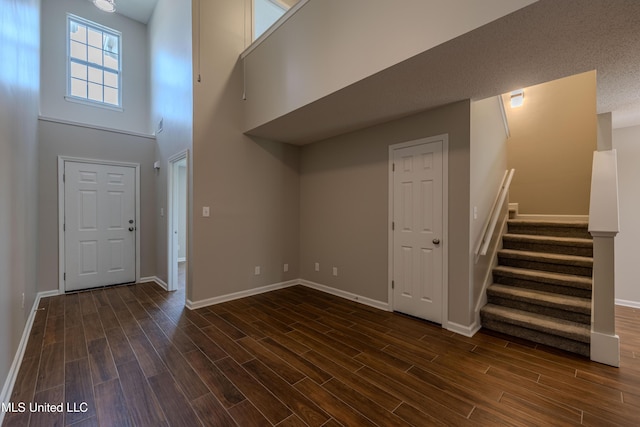 7241 Illinois Central Ave, Horn Lake, MS 38637 - foyer entrance featuring stairs, baseboards, dark wood-style flooring, and a high ceiling