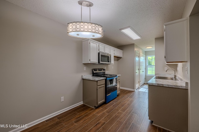 7241 Illinois Central Ave, Horn Lake, MS 38637 - kitchen featuring stainless steel appliances, a textured ceiling, a sink, light countertops, and dark wood-style flooring