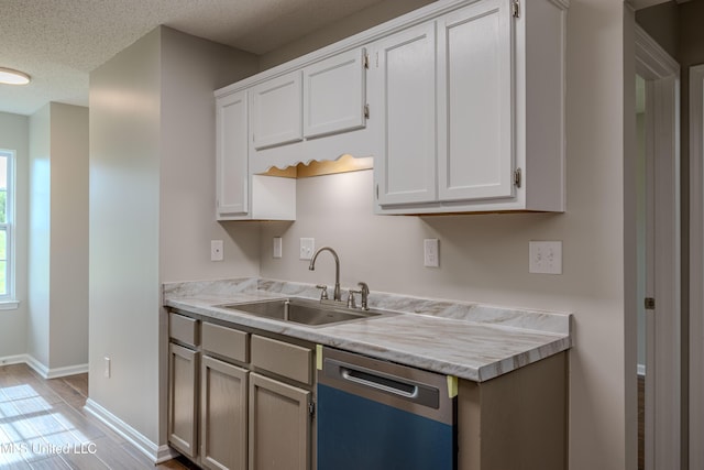 7241 Illinois Central Ave, Horn Lake, MS 38637 - kitchen featuring dishwasher, a sink, light countertops, baseboards, and white cabinets
