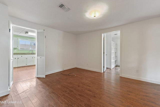 spare room with sink and hardwood / wood-style floors