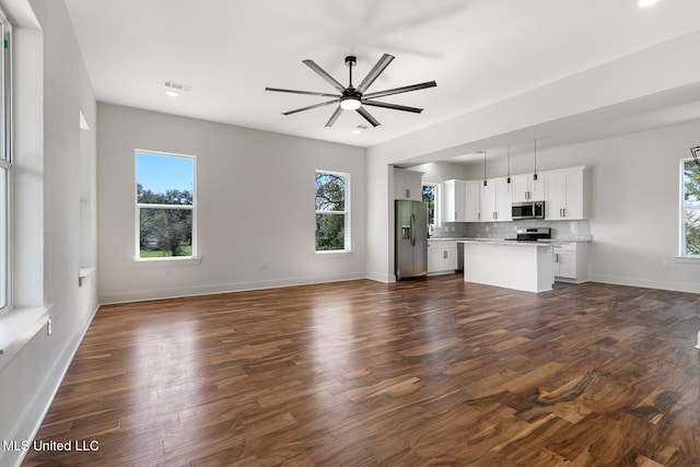 unfurnished living room with ceiling fan and dark hardwood / wood-style flooring