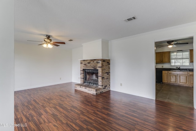115 Shady Dr, Long Beach, MS 39560 - unfurnished living room with a ceiling fan, dark wood finished floors, ornamental molding, and a brick fireplace