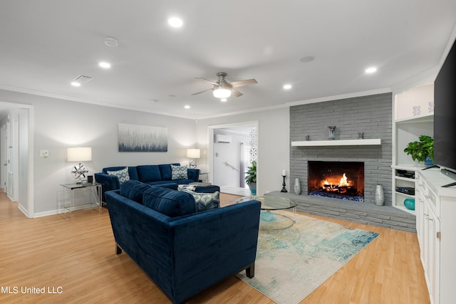 living room with light hardwood / wood-style flooring, a wall mounted air conditioner, ornamental molding, a fireplace, and ceiling fan