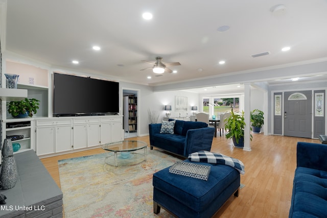 living room featuring ceiling fan, ornamental molding, and light hardwood / wood-style flooring