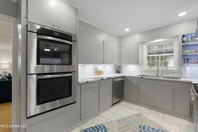 kitchen with sink, decorative backsplash, stainless steel appliances, gray cabinets, and ornamental molding