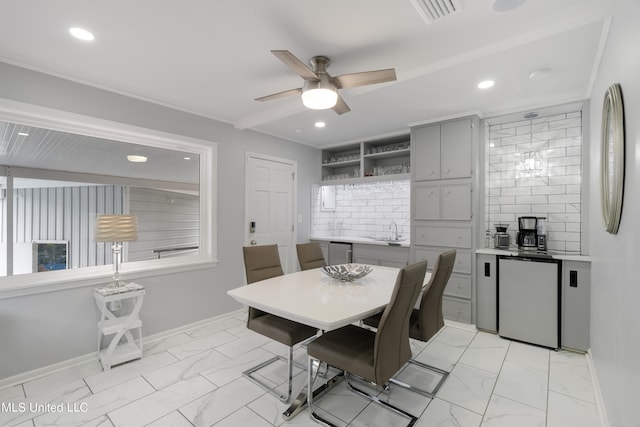 dining room featuring ceiling fan and sink