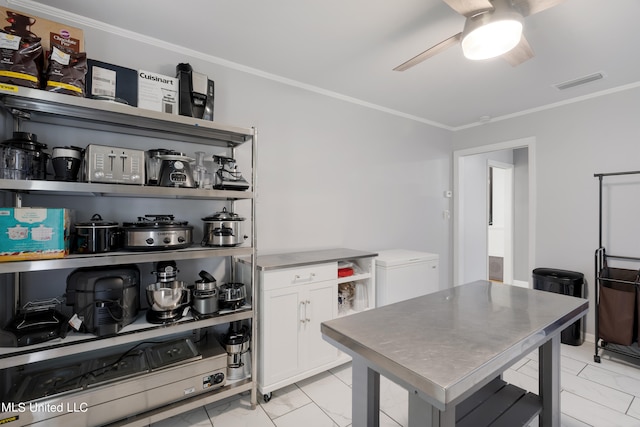 kitchen featuring ceiling fan, ornamental molding, and white cabinets