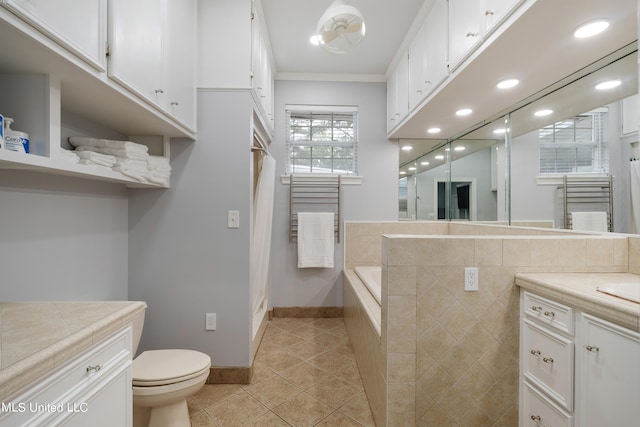 bathroom with a tub, toilet, tile patterned floors, vanity, and ornamental molding