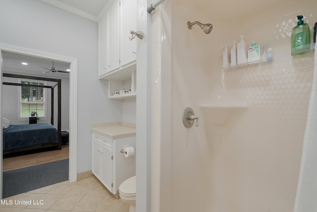 bathroom with ceiling fan, toilet, crown molding, curtained shower, and tile patterned flooring