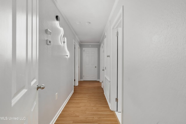 corridor with ornamental molding and light wood-type flooring