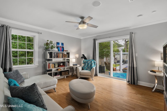 sitting room featuring crown molding, wood-type flooring, and ceiling fan