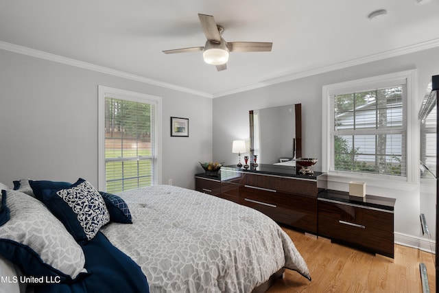 bedroom featuring ceiling fan, multiple windows, light hardwood / wood-style flooring, and crown molding