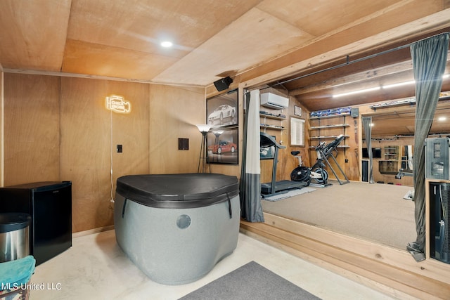 misc room featuring wooden walls, vaulted ceiling, and a wall mounted air conditioner