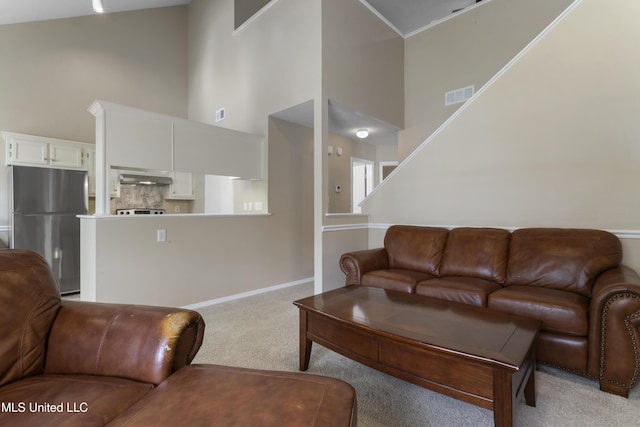 2383 Trafalgar Dr, Biloxi, MS 39531 - living area featuring light carpet, a towering ceiling, and stairway