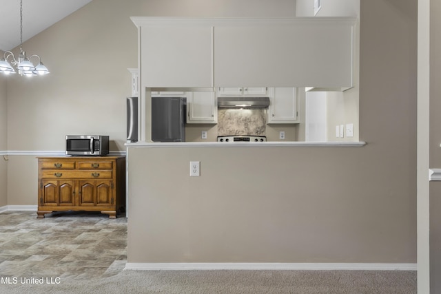 2383 Trafalgar Dr, Biloxi, MS 39531 - kitchen with fridge, stainless steel microwave, under cabinet range hood, white cabinets, and a chandelier