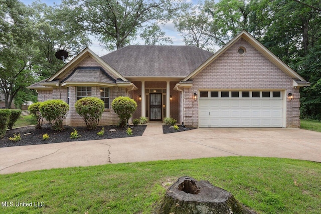 4275 Bienville Rd, Nesbit, MS 38651 - view of front of property featuring concrete driveway, a garage, a front yard, a shingled roof, and an outdoor fire pit