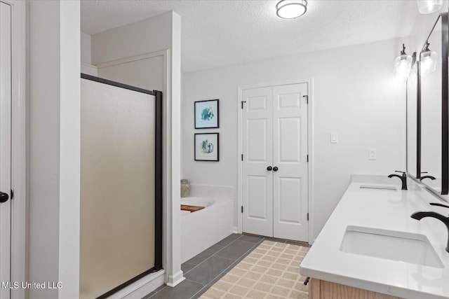 4275 Bienville Rd, Nesbit, MS 38651 - full bathroom featuring a stall shower, a garden tub, double vanity, a textured ceiling, and tile patterned flooring