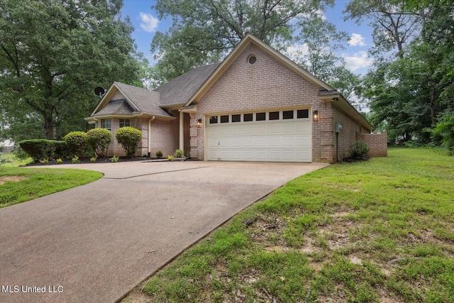 4275 Bienville Rd, Nesbit, MS 38651 - view of front of property featuring a garage, concrete driveway, a front lawn, and brick siding