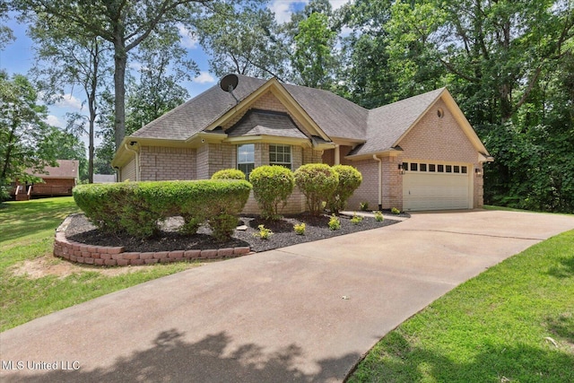 4275 Bienville Rd, Nesbit, MS 38651 - view of front facade featuring concrete driveway, an attached garage, brick siding, a front lawn, and a shingled roof