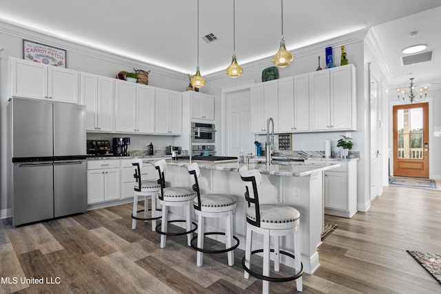 14 Sherman Ave, Pass Christian, MS 39571 - kitchen featuring a breakfast bar, white cabinets, crown molding, visible vents, and appliances with stainless steel finishes