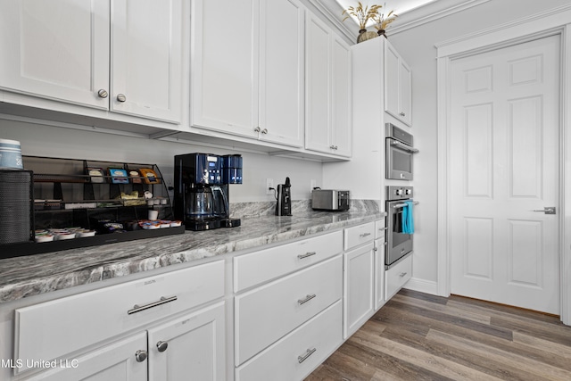 14 Sherman Ave, Pass Christian, MS 39571 - kitchen with white cabinets, wood finished floors, light stone counters, and stainless steel double oven