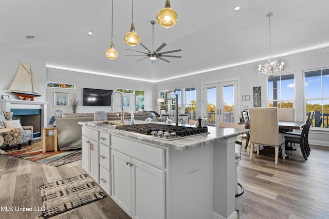 14 Sherman Ave, Pass Christian, MS 39571 - kitchen featuring ceiling fan with notable chandelier, a sink, open floor plan, crown molding, and stainless steel gas stovetop