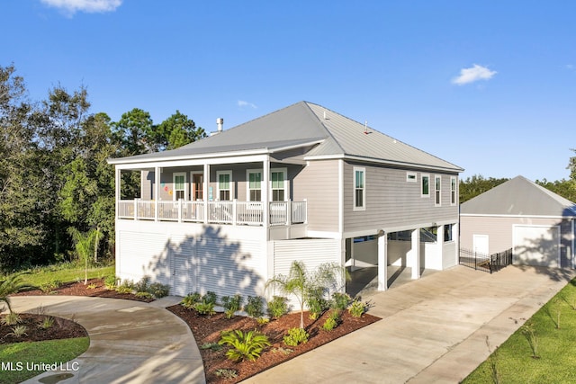 14 Sherman Ave, Pass Christian, MS 39571 - view of front of house with concrete driveway, a porch, metal roof, and an outbuilding