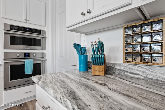 14 Sherman Ave, Pass Christian, MS 39571 - kitchen with light stone countertops, wood finished floors, double oven, and white cabinets
