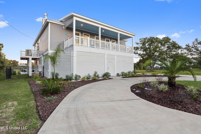 14 Sherman Ave, Pass Christian, MS 39571 - view of front of home featuring fence, curved driveway, and a balcony