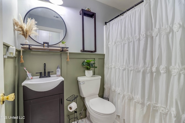 bathroom featuring toilet, vanity, and a shower with shower curtain