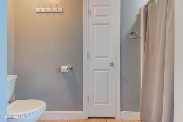 bathroom featuring tile patterned flooring, toilet, and a shower with curtain