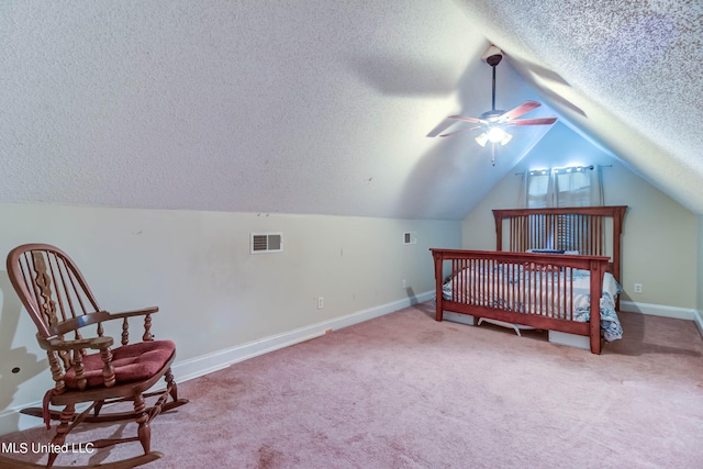 carpeted bedroom with a textured ceiling and vaulted ceiling