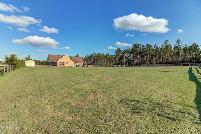 view of yard with a rural view and a shed