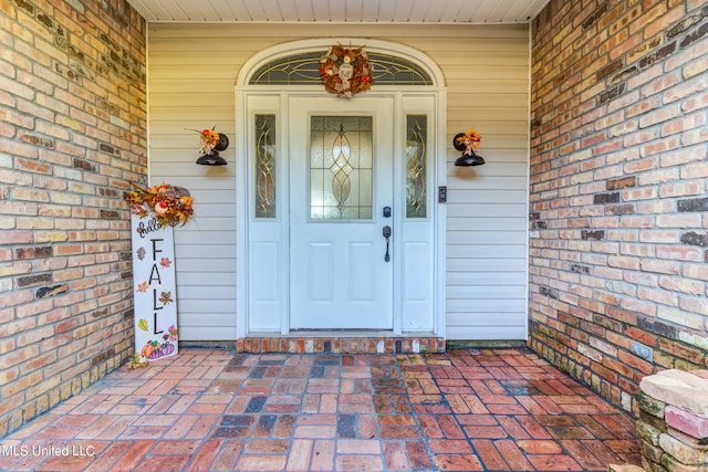 view of exterior entry featuring covered porch