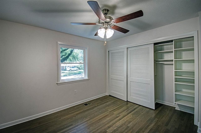 unfurnished bedroom with dark hardwood / wood-style floors, a closet, and ceiling fan