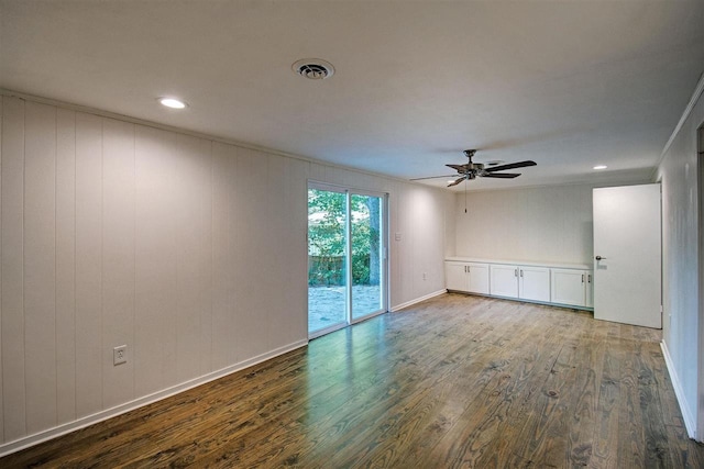 unfurnished room featuring hardwood / wood-style flooring, wooden walls, and ceiling fan