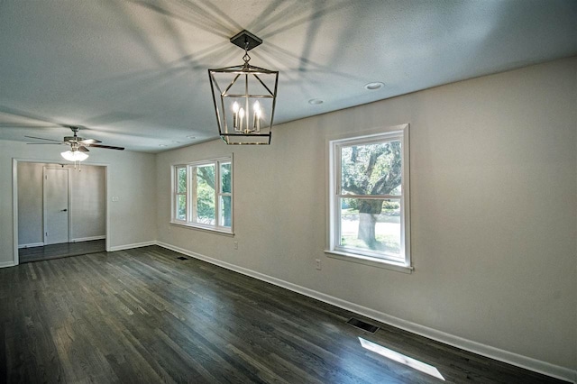 unfurnished room featuring dark wood-type flooring and ceiling fan with notable chandelier