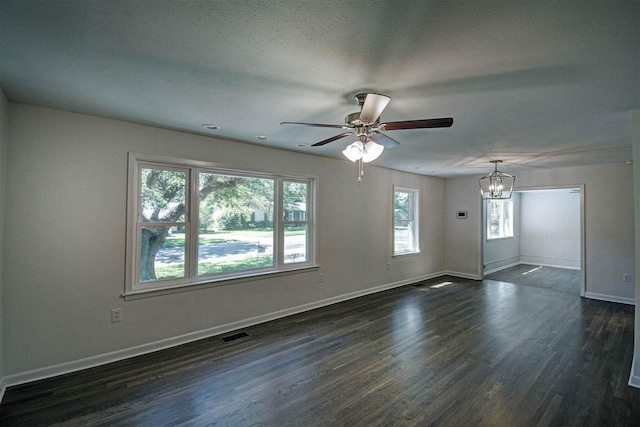 spare room featuring a textured ceiling, dark hardwood / wood-style floors, and ceiling fan with notable chandelier