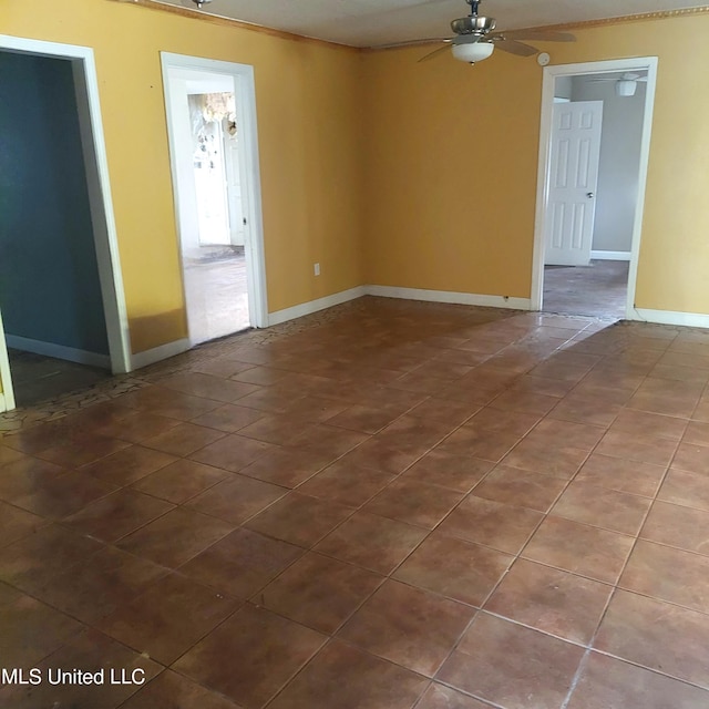 tiled spare room with ceiling fan and baseboards