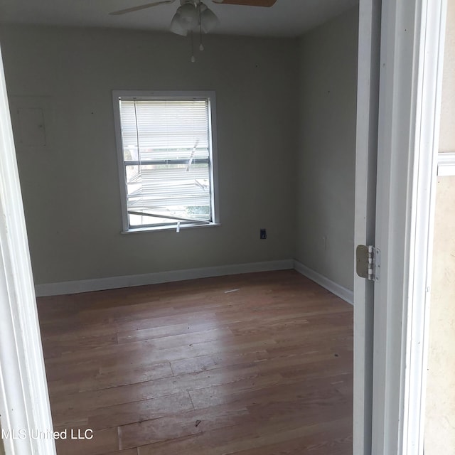 spare room with a ceiling fan, baseboards, and wood finished floors