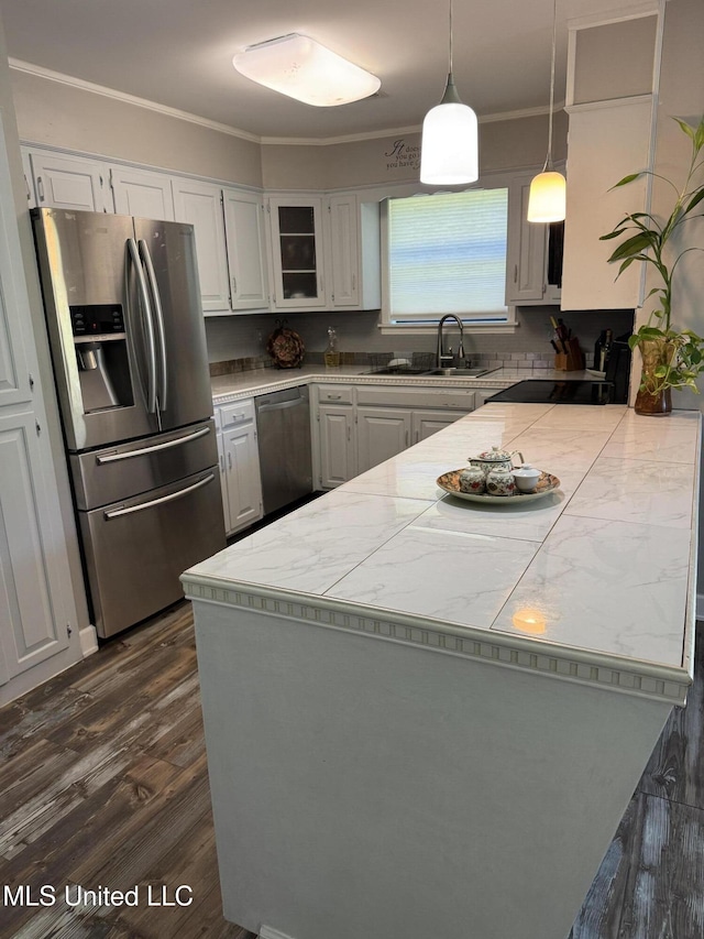 5205 Marthavale Cv, Southaven, MS 38671 - kitchen featuring appliances with stainless steel finishes, a peninsula, a sink, ornamental molding, and white cabinets