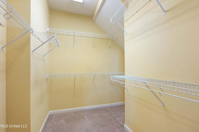 spacious closet with carpet and vaulted ceiling