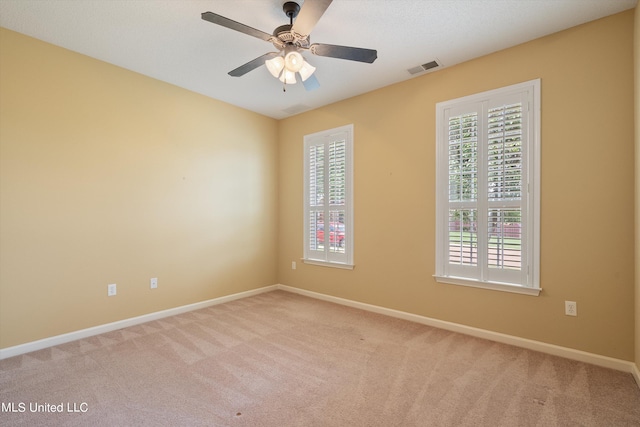 carpeted spare room with ceiling fan