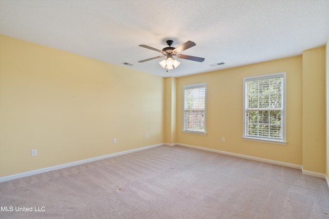 carpeted empty room featuring a textured ceiling and ceiling fan