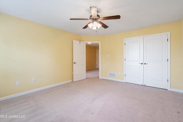 unfurnished bedroom featuring a closet, ceiling fan, and light colored carpet