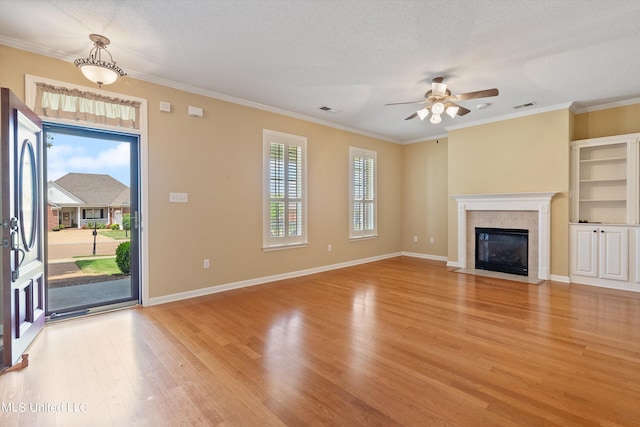 unfurnished living room with light hardwood / wood-style flooring, a textured ceiling, and plenty of natural light