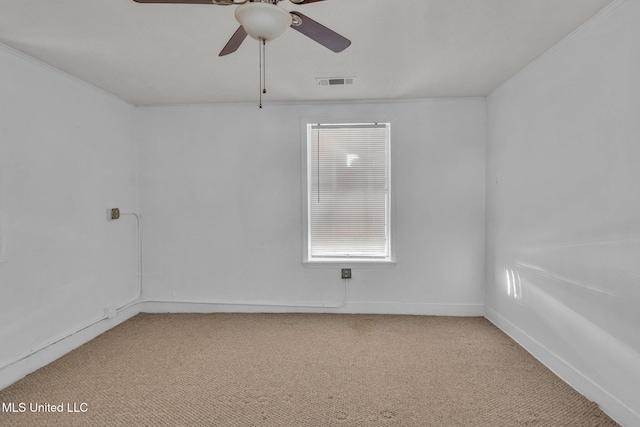 unfurnished room with light carpet, a ceiling fan, visible vents, and crown molding