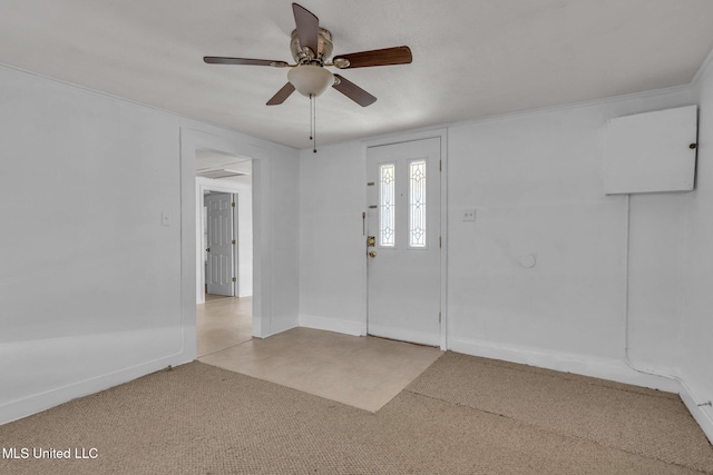 entryway with ceiling fan, carpet floors, and baseboards