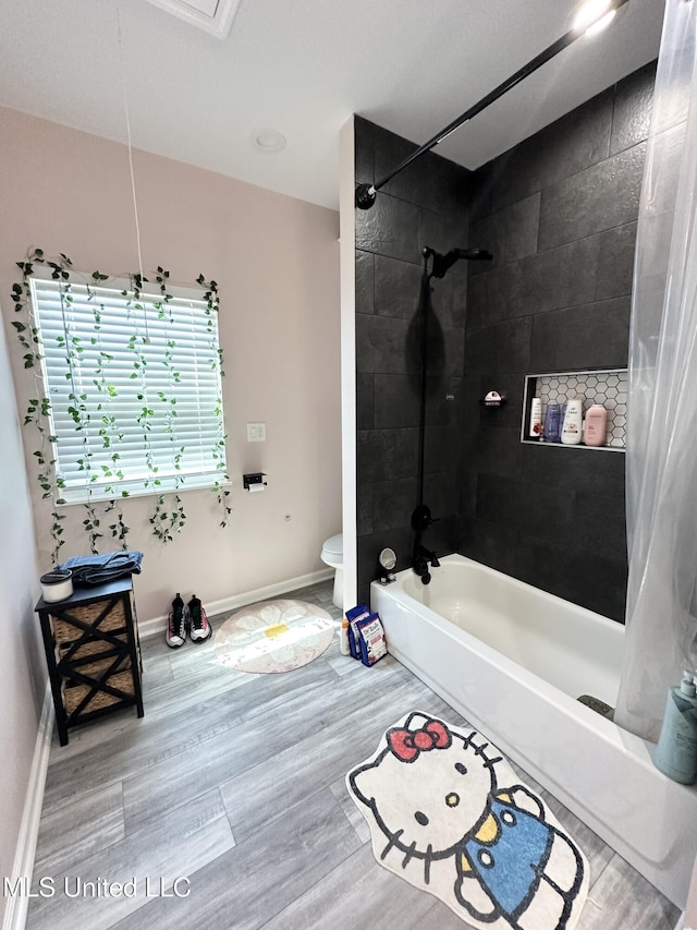 full bathroom with shower / bath combo, baseboards, toilet, and wood finished floors
